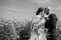 Bruidspaar tijdens fotoshoot - fotoshoot Witmarsum - bloemenveld - fotograaf lindafoto.nl
